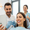 Happy patient and dentist celebrating the successful final fitting of Emax and laminate veneers in Turkey.